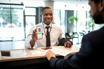 Businessman showing a vaccine certificate at the hotel reception