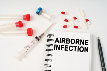 On the table are pills, injections, a syringe and a notepad with the inscription - AIRBORNE INFECTION