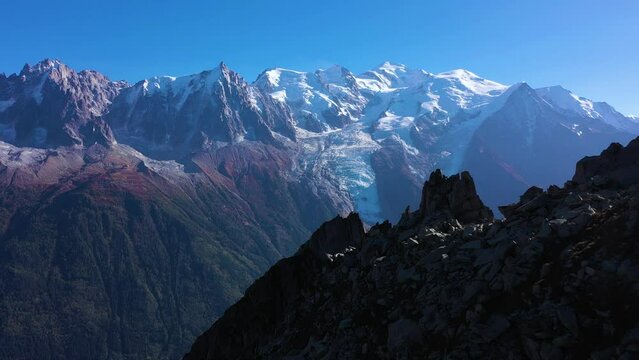 Mont Blanc and Aiguille du Midi Mountains on Sunny Day. French Alps, France. Aerial View. Drone Flies Forward over a Rocky Mountain at Low Level