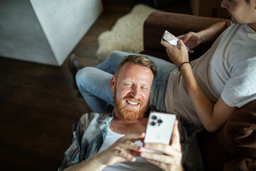 A relaxed moment shared between a young gay couple on their sofa