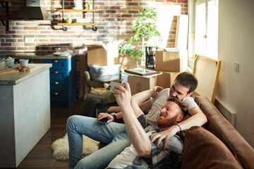 A young gay couple sharing a tender moment at home - Powered by Adobe
