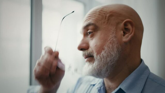 Sad man in his 40s looking out the window, bad day, feeling disappointed