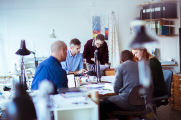 Diverse team of professionals discussing architectural designs in an office - obrazy, fototapety, plakaty