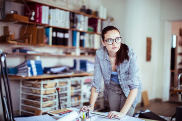 Thoughtful architect pondering over design blueprints in a vibrant workspace