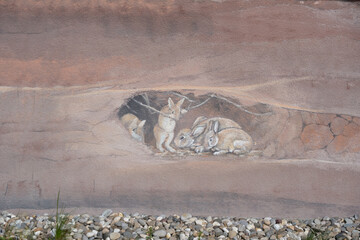 Mural graffiti of the base of a high-rise building in Langen, Hesse with painted brown earth layers...