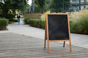 Empty sandwich chalkboard stand on street to fill