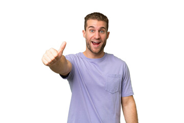 Naklejka premium Young handsome caucasian man isolated on green chroma background with thumbs up because something good has happened