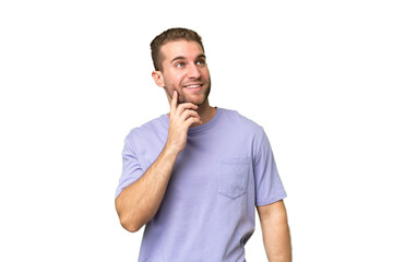 Young handsome caucasian man isolated on green chroma background thinking an idea while looking up