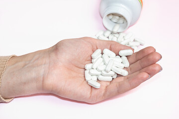 Woman holding pills in her hands. Drugs use for treatment the disease.