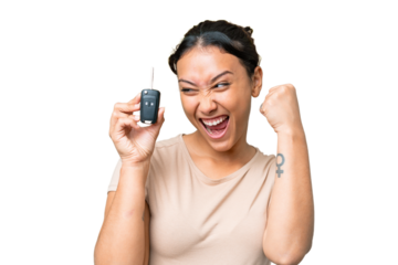 Young Uruguayan woman holding car keys over isolated chroma key background celebrating a victory