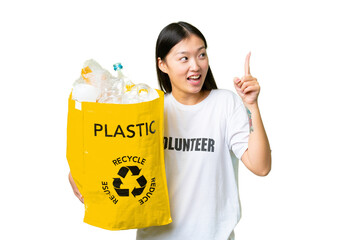 Young Asian woman holding a bag full of plastic bottles to recycle over isolated chroma key...