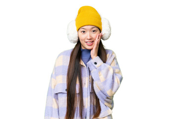 Young Asian woman wearing winter muffs over isolated chroma key background with surprise and shocked facial expression