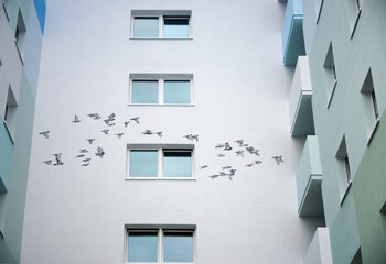 urban mural streetart graffiti at a high-rise skyscraper building in Langen, Hesse with painted flying birds in sky in silicate paint © ullision