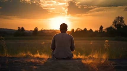 Fotobehang silhouette of a person kneeling in prayer, with a golden sunset in the background, creating a sense of peace and devotion. generative AI © yj