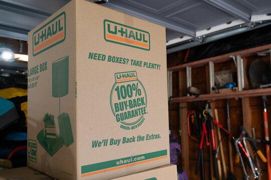 New Hope, Minnesota - October 14, 2023: U-Haul cardboard moving box, packed in a garage, ready for moving