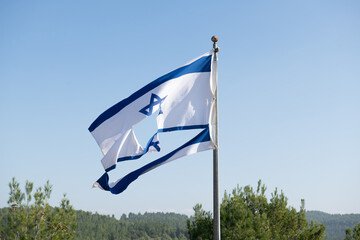 Torn Israeli flag flutters in the wind