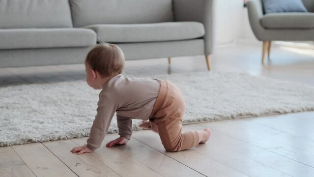 Playful toddler joyfully explores the floor, crawling with curiosity. His giggles and babbles fill the air, adding a melody of innocence and delight to the room and eyes sparkle with wonder.