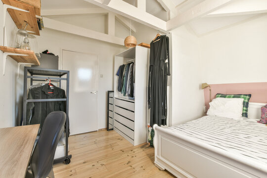Interior of bedroom with bed and clothes