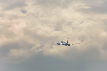Fototapeta na wymiar airplane in flight in the sky with dense clouds