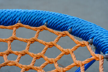 Round swing-nest close-up, details of cables and ropes on the playground