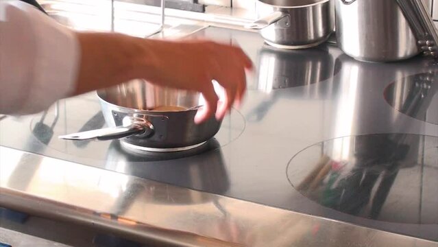 Un cuoco prepara un brodo in una cucina professionale