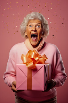 Happy Older Woman Opening A Big Present Box On Solid Background.