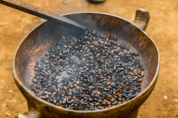Heap of the roasted coffee beans in wooden plate