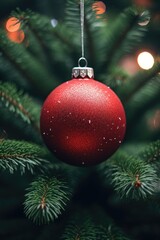 A red ornament hanging from a Christmas tree. Perfect for holiday decorations and festive designs