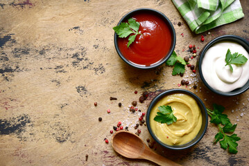 Set of popular sauces in a black bowls . Top view with copy space.