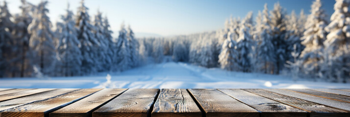 A wooden table boards and blurred defocused snow covered trees in the background. - obrazy, fototapety, plakaty