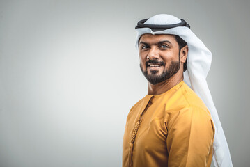 Arabian man wearing traditional emirati dishdasha kandura in studio - Portrait of middle-eastern male adult with beard