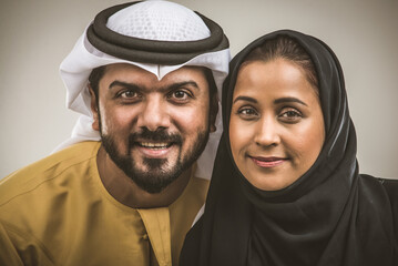 Arabian couple isolated wearing traditional middle-eastern clothing on grey background