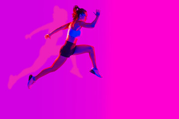 Fototapeta na wymiar Sportive beautiful woman training with athletic body and sportswear doing workout, colorful lighting and background