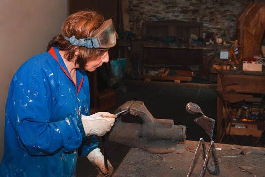 Artisan chiseling metal