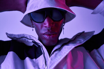 Closeup of Stylish black man wearing sunglasses and hat in studio