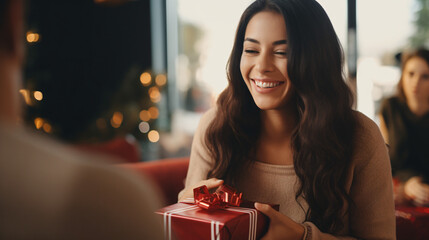 Laughing woman handing over gift to friend - obrazy, fototapety, plakaty