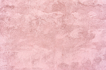 Relief texture of pink plaster with small cracks. Abstract background