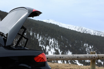 a car stopped on the road with an open trunk, with a view of the mountain, concept of travel or breakdowns on the road.