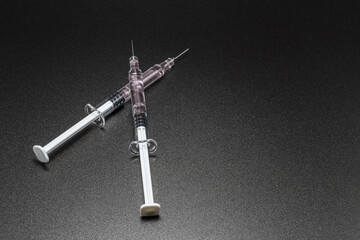 Medical syringes and needles on black background. Medical concept, laboratory, subcutaneous injection vaccination, dose. Disease treatment immunization. Concept of anti drugs.