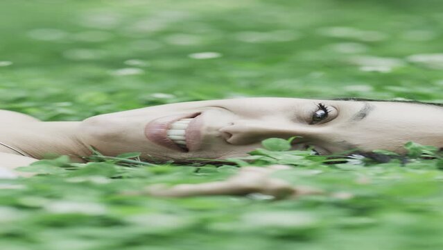 Close up panning shot of woman laying in field of wildflowers  - vertical video / Kazanluk, Bulgaria