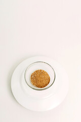Dry ground ginger in a glass plate on a white background.