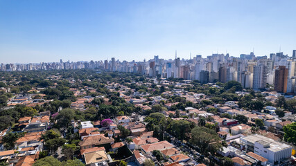 Obraz premium Residential buildings and houses in the Itaim Bibi neighborhood in São Paulo, Brazil. Aerial view of Ibirapuera Park with buildings in the background.