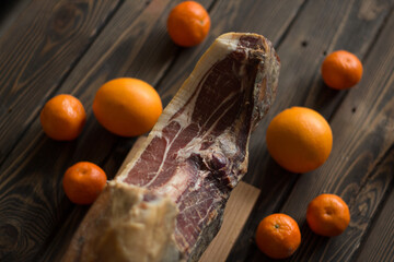 Top view of whole Serrano ham and oranges