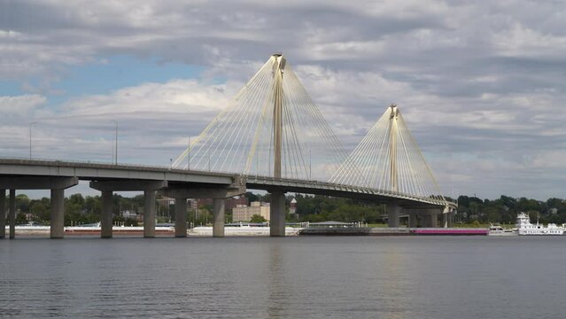 towboat with barges and a recreational boat are passing under the cable-stayed  Clark Bridge on the Mississippi River at Alton, Illinois