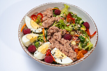 tuna salad with lettuce and eggs, lamb and fruit, fresh salad in a plate on a white background	
