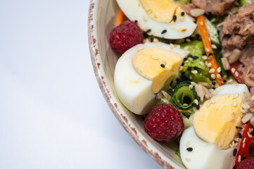 tuna salad with lettuce and eggs, lamb and fruit, fresh salad in a plate on a white background