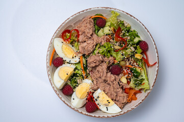 tuna salad with lettuce and eggs, lamb and fruit, fresh salad in a plate on a white background	
