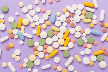 Different medical pills and capsules on color background, top view