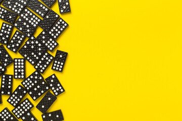 Black domino tiles on color background, top view