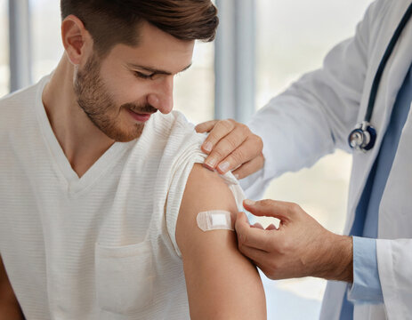 A young man getting a vaccine, and the doctor hands with plaster on the patient arm closeup. Generative AI